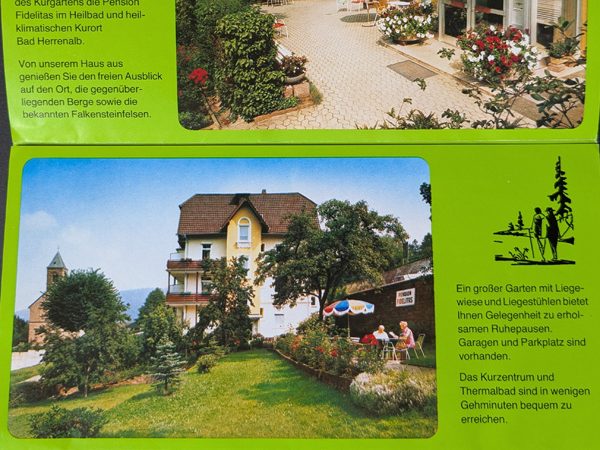 Schöne Gartenlandschaft mit einem großen Haus und blühenden Pflanzen im Hintergrund.