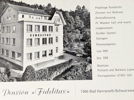 Historisches Gebäude mit Beschriftung "Pension Fidelitas", umgeben von Grünanlagen.